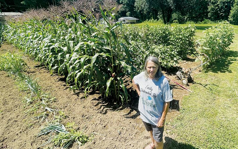 Flanked by her agricultural production, Vicki Walsh proudly shows off the garden she has cultivated on Lower Mill Creek Road. Photos by Randy Foster/news@grahamstar.com