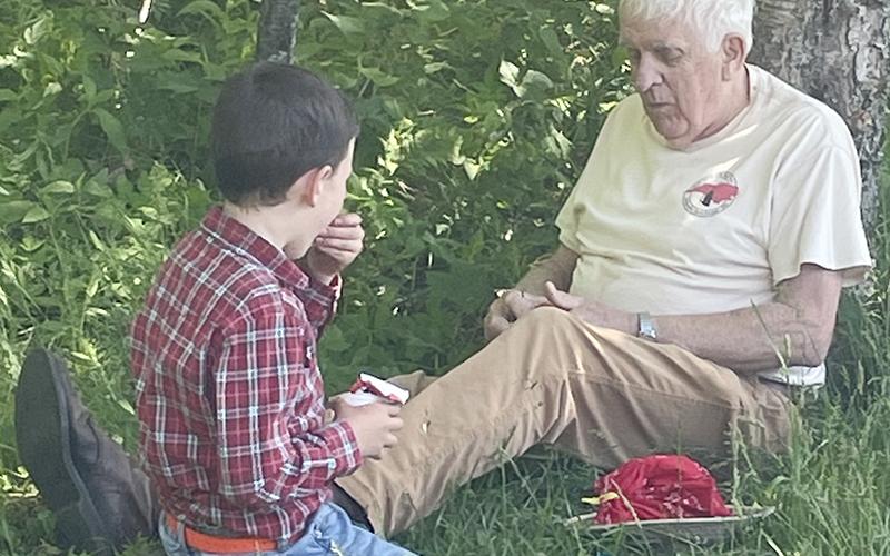 Marshall Stewart, age 8, and Graham Star columnist Marshall McClung enjoy lunch after hiking to Oak Knob and Big Huckleberry on a recent 4-H trip. Photo courtesy of Nikki Stewart/Contributing Photographer