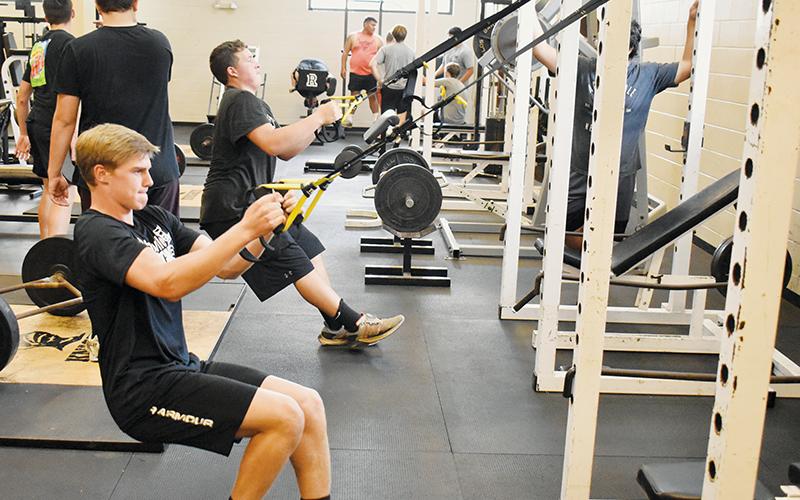 Cooper Adams (foreground) and Dayne Webster work out in the Robbinsville weight room before Tuesday’s practice.