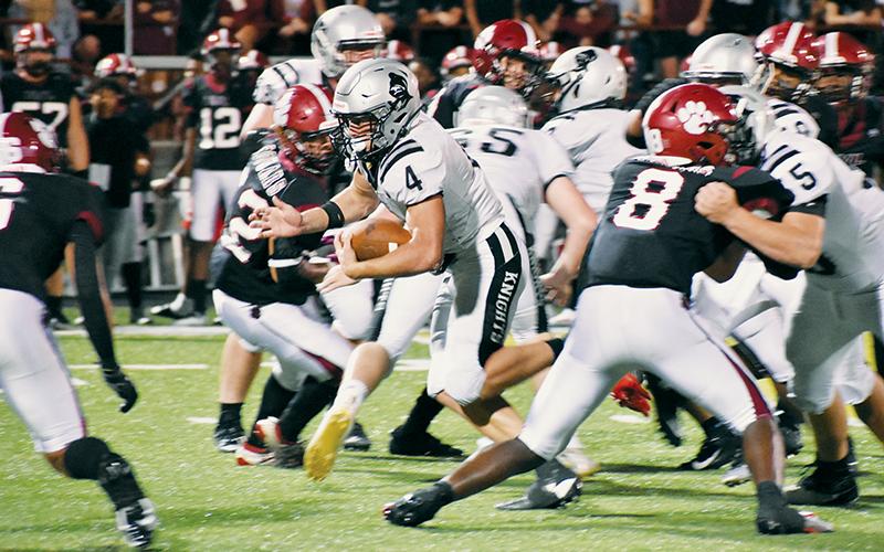 Junior running back Cuttler Adams (4) emerges from a mixture of Knights and Cougars in Friday’s season opener at Asheville. Adams finished the game with 153 rushing yards. Photos by Kevin Hensley/sports@grahamstar.com