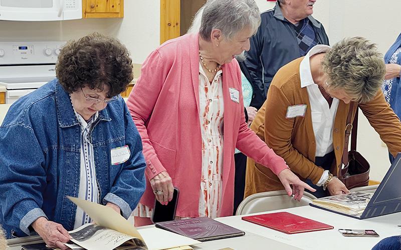 Patsy Owens Rogers (center) goes over high school yearbooks with Mountain View High School alumni Nahala Ayers Nichols (left) and Judy Williams Biddix during a reunion on Saturday. Rogers started the annual reunion in 2019 along with her late brother, Richard. Photo by Randy Foster/news@grahamstar.com