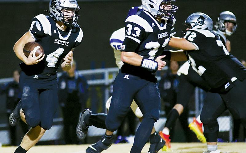 Robbinsville junior Cuttler Adams (4) looks to net positive yardage as his classmate Kage Williams runs to protect the effort Friday against Cherryville. Between the two, four touchdowns and over 200 yards of rushing were recorded in the Knights’ first-round victory. Photo by Miranda Buchanan/Robbinsville High School Yearbook