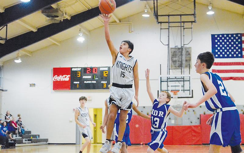 Surrounded by a flock of Eagles, Xamuel Wachacha soars toward the basket during the Nov. 3 season opener against Hiwassee Dam/Ranger. Photo by Kevin Hensley/sports@grahamstar.com