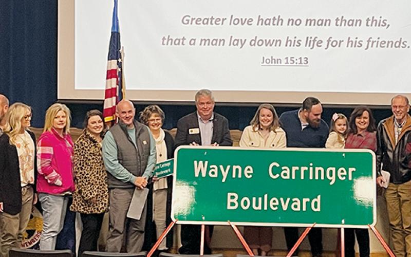 Family members pose with the new street sign for Wayne Carringer Boulevard, during a dedication ceremony at Robbinsville High School on Friday. Photo by Randy Foster/news@grahamstar.com