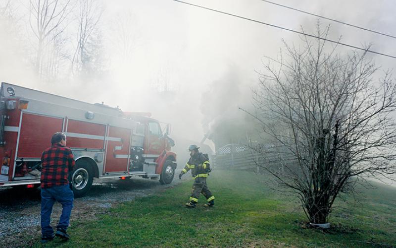 Unidentified firefighters prepare their gear while fighting a house fire at 1005 Hares Creek Road on Tuesday, Dec. 13. Photos by Randy Foster/news@grahamstar.com