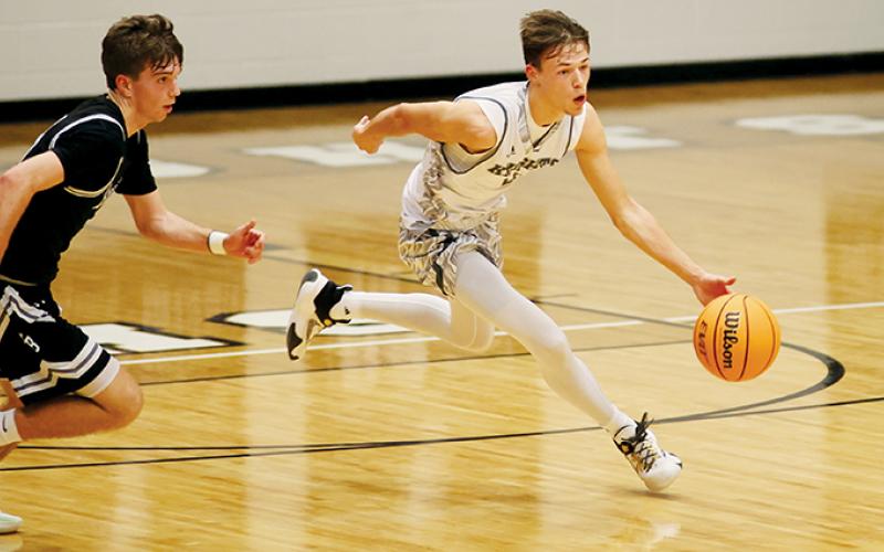 Senior point guard Brock Adams (right) breaks away from a North Buncombe defender in the first half of  Robbinsville’s double-overtime win over the Blackhawks on Friday. Photo by Miranda Buchanan/Robbinsville High School Yearbook