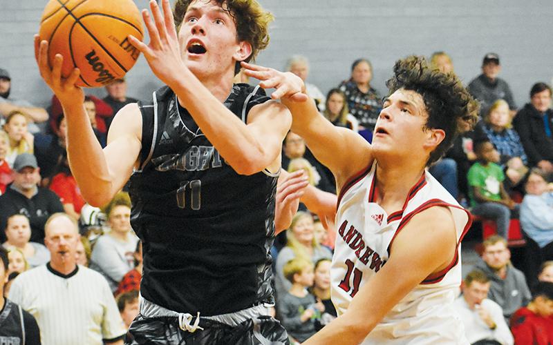 Despite the best efforts of Wildcat Cameron Rattler, Robbinsville  junior shooting guard Donovan Carpenter soars toward the net during Tuesday’s win over Andrews. Photos by Kevin Hensley/sports@grahamstar.com