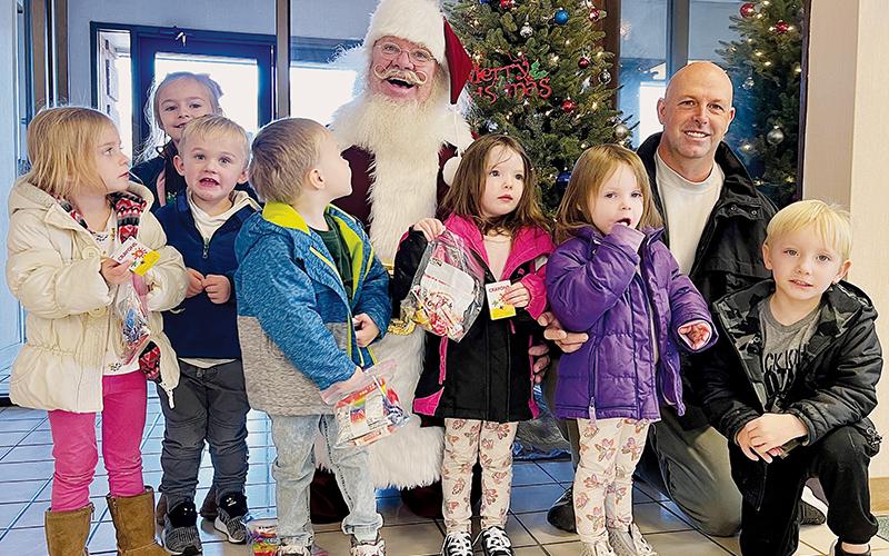 Santa Claus paid a return visit to Robbinsville on Monday, visiting with 3- and 4-year-olds at the Graham County Sheriff’s Office. Along with Santa and Sheriff Brad Hoxit, the children are (from left) Summer Phillips, Grace Birchfield, Creighton Edwards, Cayson Bumgardner, Averleigh Phillips, Cayzleigh Phillips and Gage Pilkington.