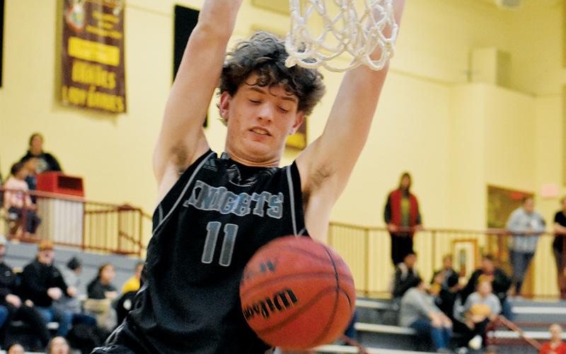 Donovan Carpenter glances down at his handiwork in the closing seconds of Tuesday’s comeback victory at Cherokee. Carpenter’s dunk resoundingly affirmed a 58-48 win for the Black Knights. Photo by Kevin Hensley/sports@grahamstar.com
