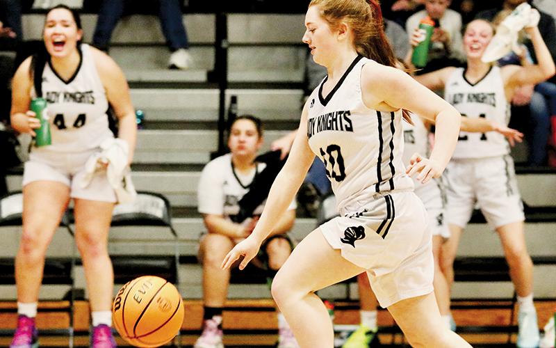Aubrie Wachacha (44) and Kensley Phillips (24) leap to their feet from the bench in the closing moments of Monday's win over Hiwassee Dam, to root on sophomore Olivia Lewis' breakaway bucket. Photo courtesy of Aspyn Phillips/Robbinsville High School Yearbook