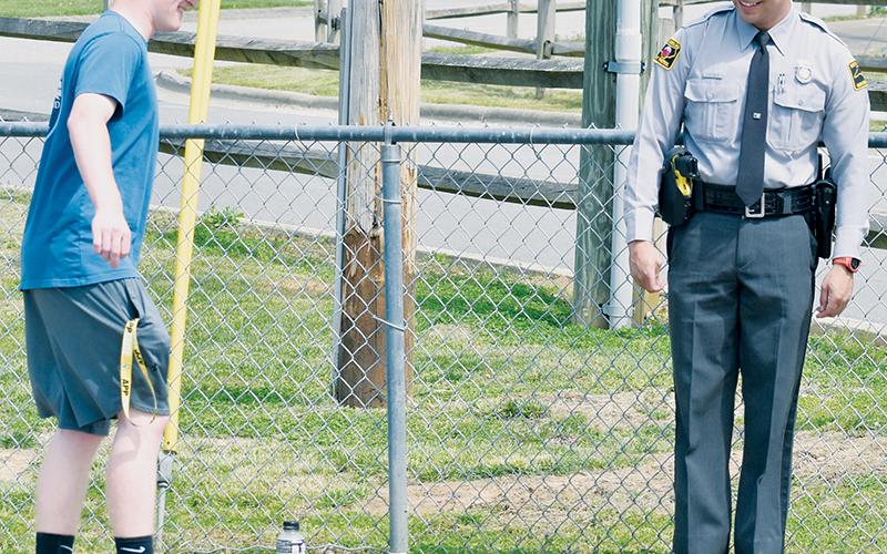 Senior Caleb Turpin attempts to balance on one foot – a common technique used when administering field-sobriety tests – as Trooper Johnathon Jones looks on during April 5’s STAND T.A.L.L. demonstration.