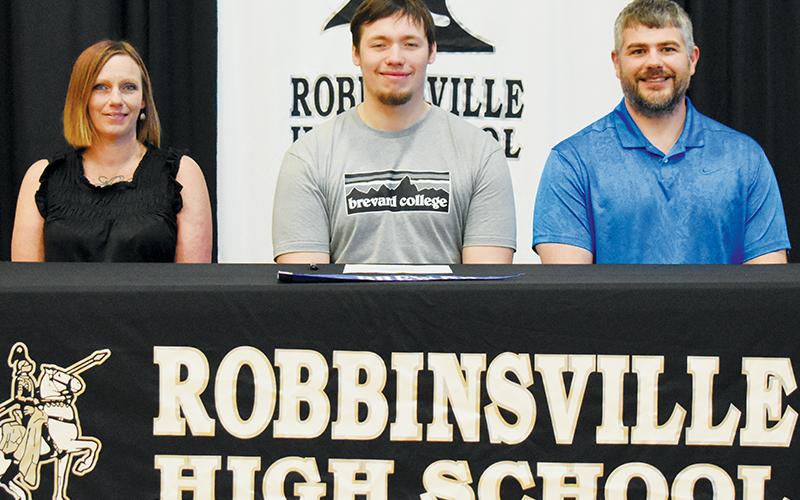 Haden Key signed to play football at Brevard College on May 3. Sitting with Key are his mother Joanna and coach Wren Millsaps. Photo by Kevin Hensley/sports@grahamstar.com