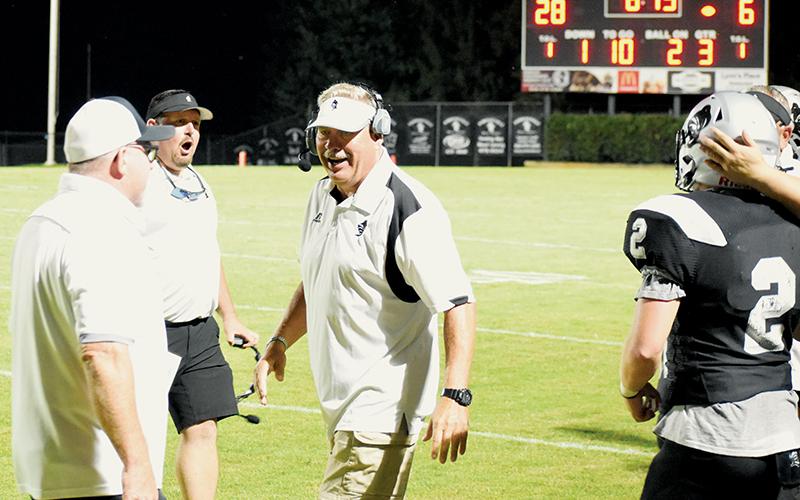 Robbinsville coaches Randy Moody, Lucas Ford and Dee Walsh (clockwise, from left) all commend senior Chase Calhoun (2) after his pivotal fourth-down tackle Friday against East Surry, which solidified a crucial goal-line stand for the Black Knights in the season-opening victory. Photo by Danielle Crabtree/The Graham Star