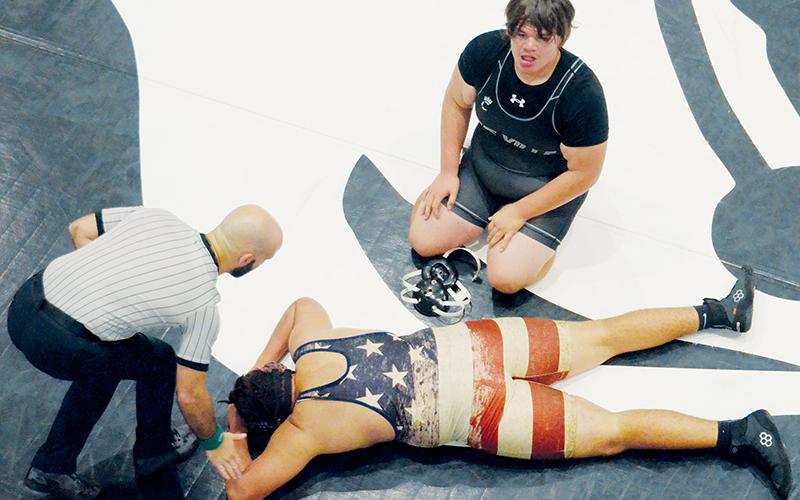 An exhausted Jacob Teesateskie glances at his raucous teammates Nov. 15, 2022, as Madison’s Mason Clubb lays despondent on the mat. Teesateskie had just scored a takedown to prevail 7-5 in overtime against Clubb. The photograph won a second-place award from the N.C. Press Association’s yearly editorial contest, in the “Photography, Sports” competition. Photo by Kevin Hensley/sports@grahamstar.com