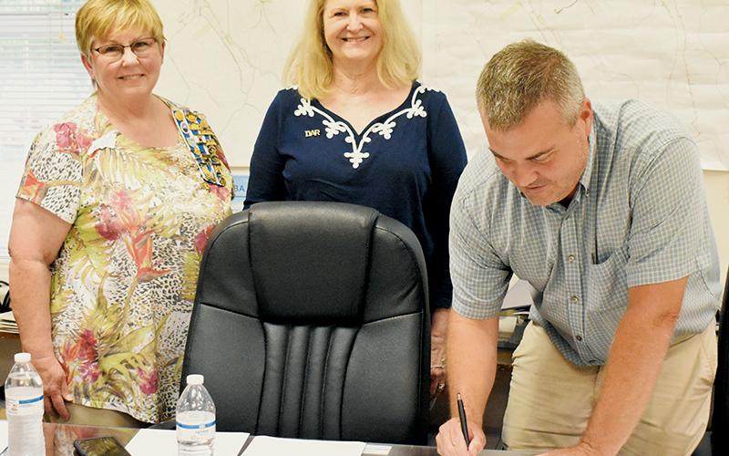 Lynn Deeden (left) and Victoria Baker – representing the Daughters of the American Revolution – oversee Robbinsville Mayor Shaun Adams’ signing of the annual  Constitutional Week Proclamation at Tuesday’s board of aldermen meeting. This year, the recognition will run from Sunday, Sept. 17 – Saturday, Sept. 23. Photo by Kevin Hensley/editor@grahamstar.com