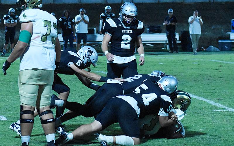 The “Black Knight Swarm” that has made waves all year – this time, compromised of Bryce Adams (6), Quinn Jumper (12), Kellen Ensley (54) and Chase Calhoun (2) – combines forces to stop Rabun Gap’s Anthony Quinn, Jr. on Friday night. Photo by Danielle Crabtree/The Graham Star