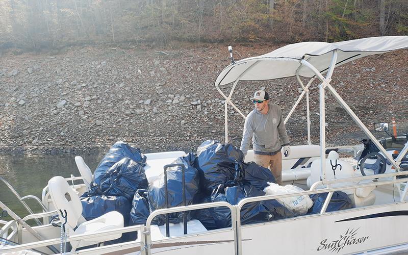 Fontana Village Marina Manager Brandon Jones helps unload trash during the Fontana Lakeshore Cleanup on Saturday. Photo by Ruby Annas/news@grahamstar.com