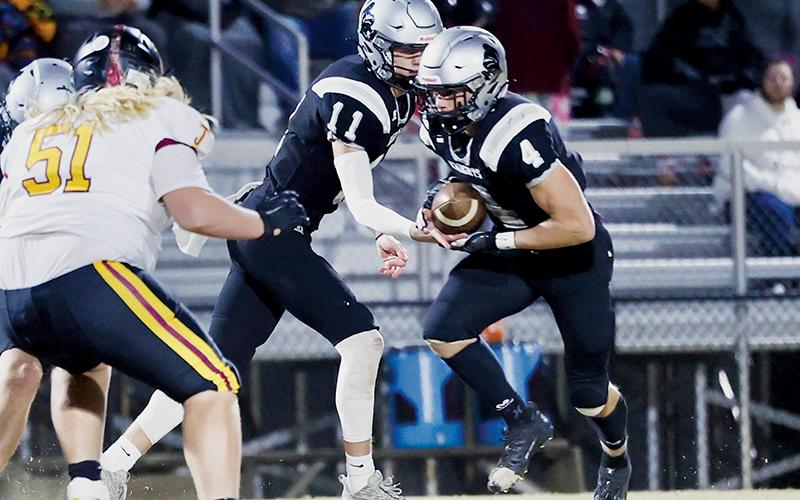 Cuttler Adams (4) takes the handoff from Robbinsville quarterback Donovan  Carpenter during the 2023 playoff opener Friday against Thomas Jefferson Classical Academy. Adams broke both the all-time rushing record for the Black Knights and the Smoky Mountain Conference early in the game. Photo courtesy of Miranda Buchanan/Robbinsville High School