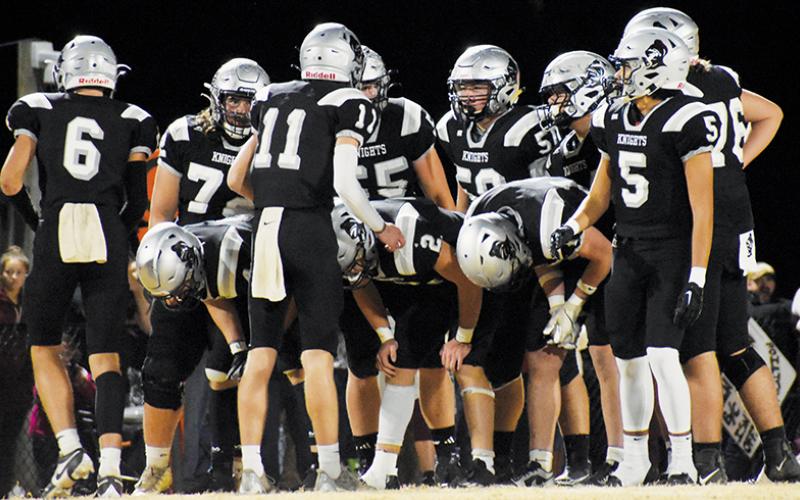 Senior quarterback Donovan Carpenter gives instruction to the Robbinsville Black Knights’ offense prior to a first-half play in the third round of the 1A state playoffs Friday against Swain County. Carpenter heavily credited the perseverance of the Knights in the 30-24 win to the program’s main theme this year: “brotherhood.” Photo by Fala Welch/The Graham Star