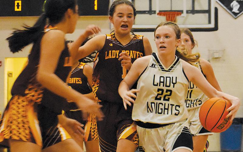 Daphne Barlow (22) cuts between the defense of  Cherokee’s Cambry Stamper (1) and Lilly Lossiah during a fourth-quarter, fast-break Monday. Photo by Kevin Hensley/sports@grahamstar.com