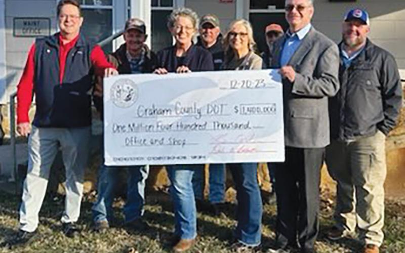 Senate 50 Rep. Kevin Corbin (left, holding check, R-Franklin) and District 120 Rep. Karl Gillespie (right, holding check, R-Franklin) spent several hours in Graham County on Dec. 20, presenting checks for various needs across the county. The tour began at the N.C. Department of Transportation’s office, where a check in the amount of $1.4 million was awarded. Photo courtesy of Kevin Corbin