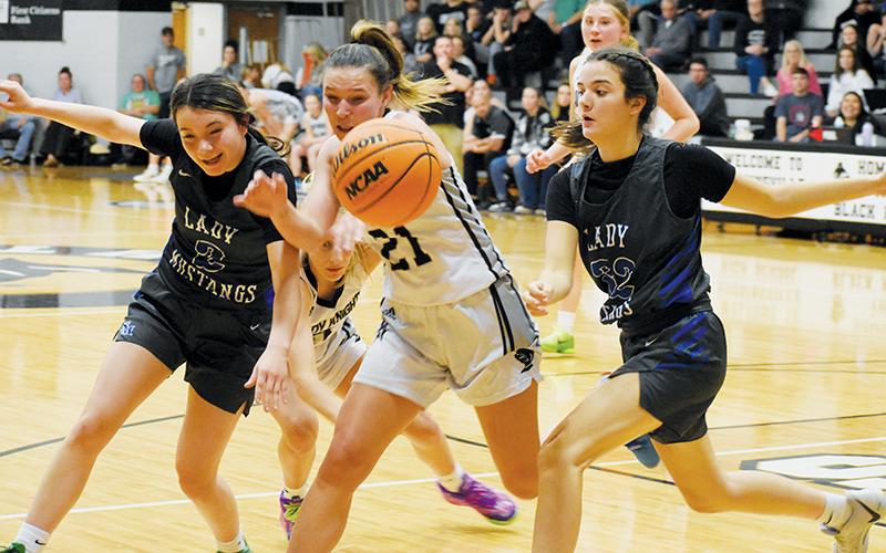 Robbinsville’s Delaney Brooms (21) jostles with Smoky Mountain’s Kieara Ensley (2) and Julia Macauley over a rebound during the Lady Knights’ win over the Lady Mustangs on Dec. 7. Photos by Fala Welch/The Graham Star