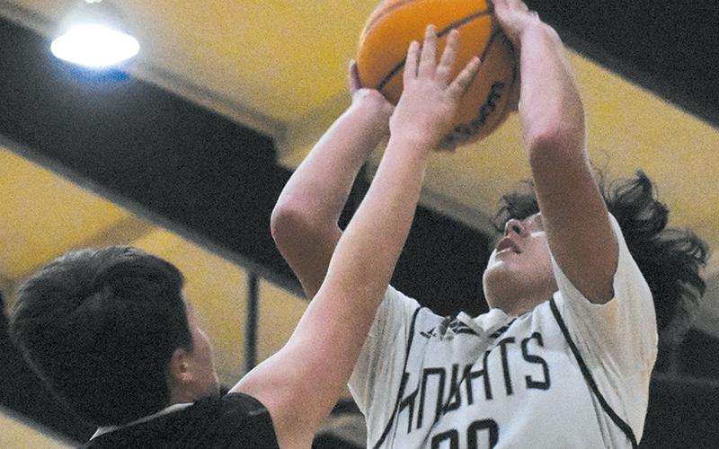 Elijah Kirkland seemingly reaches into the lights – and over the plea of Andrews’ Tanner Postell – for two of his Black Knights-best 15 points in Dec. 14’s home win over the Wildcats. Photo courtesy of Jozlyn Garland/Contributing Photographer