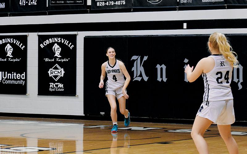 It was smiles all around for the Lady Knights during their regular-season home finale Feb. 7 against Blue Ridge School, as clearly illustrated on this throw-in from Claire Barlow (4) to Suri Watty. Photo by Audrey Colvin/The Graham Star