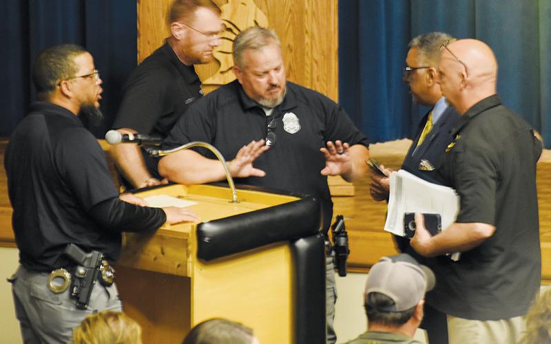 Civility went out the window late in the March 21 public forum to discuss a potential change of jurisdiction for school resource officers. Robbinsville Elementary School SRO Josh Reap (left) and Graham County Sheriff’s Office attorney David Wijewickrama (right, in suit) got into a heated argument. Standing between the two are Robbinsville Middle/High School SRO Jeff Knight; Sheriff Brad Hoxit is at far right, and the chief of detectives, Travis Brooks, is walking behind Knight. Photo by Kevin Hensley