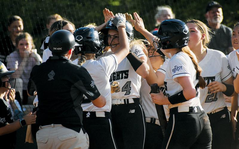 Members of the Robbinsville Lady Knights welcome sophomore Anna Williams (4) to the plate in May 2’s season finale against Murphy, after Williams launched her third home run of the year. Photo by Jacquline Gayosso/The Graham Star