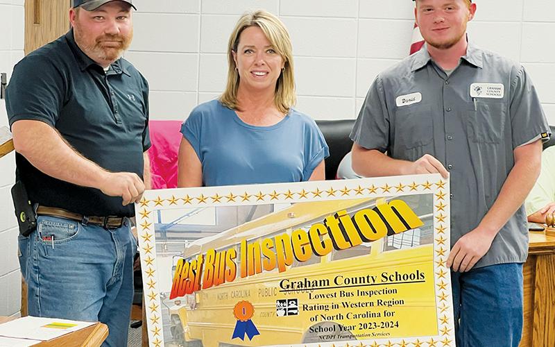 Graham County Schools received the lowest bus inspection rating in Western North Carolina from the N.C. Department of Public Inspection. The district’s transportation department was recognized at June 27’s special-called board of education meeting. From left are Adam Harkins, transportation director; Lisa Ford, transportation administrative assistant; and David Lovingood, transportation mechanic. Photo by Kevin Hensley/editor@grahamstar.com