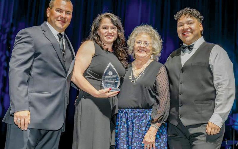 Graham County resident Susan Crowe (second from left) was presented with the Lula Owl Gloyne Person of Excellence Award at the June 15 Cherokee Indian Hospital Foundation Gala. Also pictured is Dale Robinson, Jr. (left), chairman of the Cherokee Indian Hospital Foundation; plus Judy Gloyne-Tiger and Jayden Crowe (right), family members of Lula Owl Gloyne.