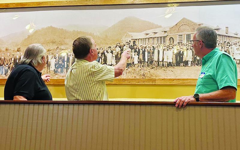 Larry Paige, Billy Cable and Dwight Bradshaw (from left) look at the 1926 dedication photo of Stecoah School inside the auditorium at Saturday’s annual reunion. Photos by Latresa Phillips/The Graham Star