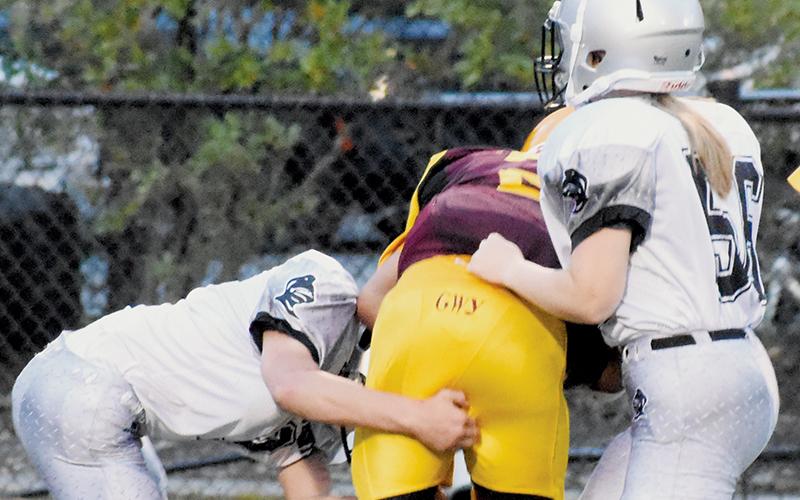 Ayden Conley (left) and Bella Eddings combine forces to drop a Cherokee runner during the closing moments of Sept. 5’s win.
