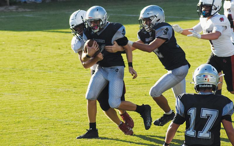 Landon Pollard attempts to shirk an Andrews defender Sept. 19. Elijah Kirkland (12) offers a helping hand for the cause. Photo by Jacquline Gayosso/The Graham Star