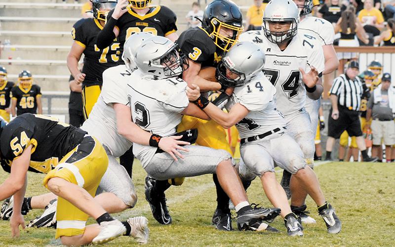 Landon Pollard (7), Elijah Kirkland (12) and Braydon Lane (14) sandwich Murphy’s Blake Davis during a rush attempt Monday.