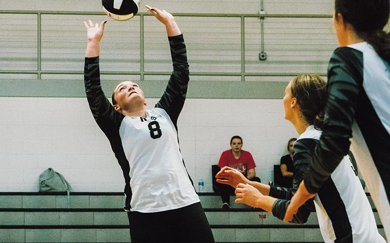With Claire Barlow (center) and Chloe Adams scrambling to get into position, junior setter Ryn Hooper makes a pass during Aug. 20’s home match against Highlands. Photo by Royce Worbington/The Graham Star