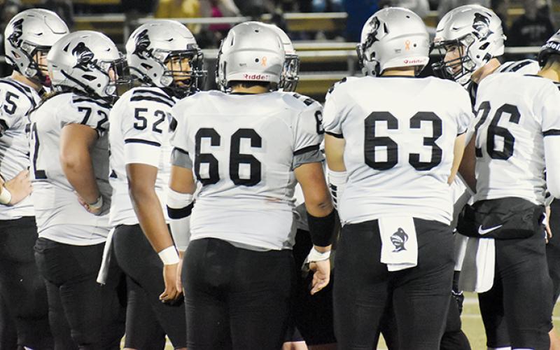 Bryce Adams (right) presents the next play to his offensive linemen and tackles during Friday’s game at Hayesville. Adams launched a trio of touchdown passes in Robbinsville’s win. Also pictured are Kasen Buchanan (55), Tytan Teesateskie (72), Kyzik Teesateskie (52), Jonah Teesateskie (66), Avery Webster (63) and Tucker Jones (26). Photo by Cheyanne Geyer/The Graham Star