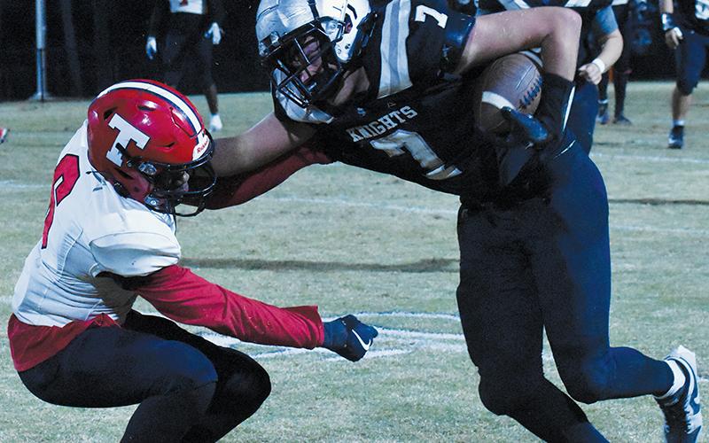 Junior fullback Isiac Collins (7) decisively denies Thomasville’s Elijah McNeair with a stiff-arm during Friday’s first-round playoff win over the Bulldogs. Photo by Bella Eddings/The Graham Star