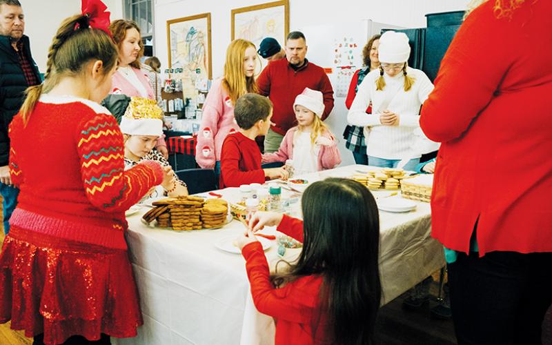 Children and adults alike gather to decorate cookies Saturday at Stecoah’s Christmas in the Mountains. Photos by Royce Worbington/The Graham Star