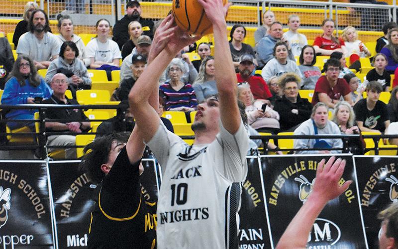 Bryce Adams looks to outmaneuver Murphy’s Connor Golden during the first half of Tuesday’s Smoky  Mountain Conference tournament semifinal. Adams  became the all-time scoring leader for Robbinsville Black Knights basketball in the game. Photo by Kevin Hensley/sports@grahamstar.com