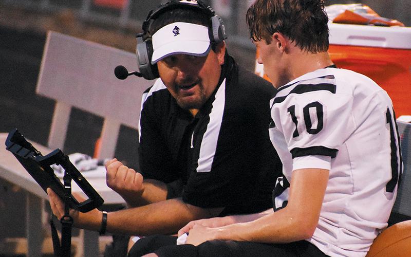 Lucas Ford reviews a play with Tanner Hedden during Aug. 30’s game at Franklin. Ford’s rapport with the players had many of the Robbinsville faithful pulling for the Black Knight alum to be appointed as the new head football coach; Feb. 6, he was announced as Dee Walsh’s successor. Photo by Kevin Hensley/sports@grahamstar.com