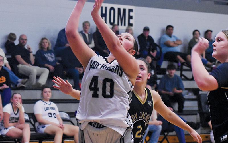 Junior varsity Lady Knight Bella Coats splits a pair of Hayesville defenders for a basket attempt Tuesday.