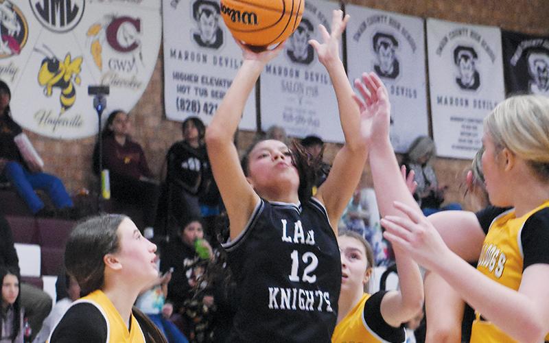 Middle school Lady Knight Aaliyah Wolfe splits a pair of Murphy defenders to unload a second-half jumper during Jan. 29’s conference-tournament semifinals. Photos by Kevin Hensley/sports@grahamstar.com