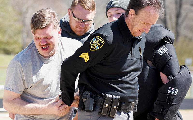 Zeke Silvers cuffs deputy sheriff Randy Price just minutes after being pepper sprayed as part of Friday’s certification.