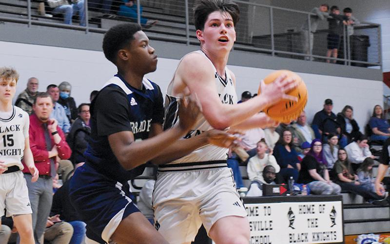 Robbinsville senior Roman Jones tries to shirk a Bradford Prep defender while  charging toward the basket during Tuesday’s first-round playoff game. Photo by Bella Eddings/The Graham Star