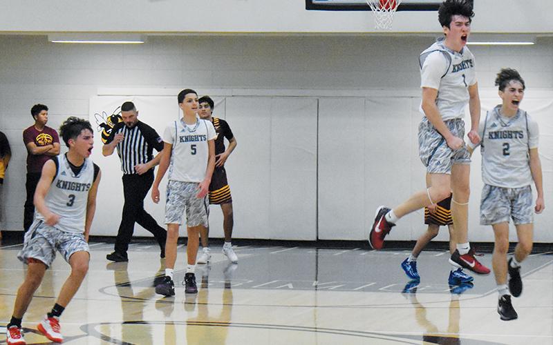 Moments after the final buzzer sounded Saturday, JV Black Knights Xamuel Wachacha (3), Tucker Jones (5), Bam Nelms (1) and Eli Lambert (2) begin to celebrate Robbinsville’s Smoky Mountain Conference tournament-title victory. Photos by Kevin Hensley/sports@grahamstar.com