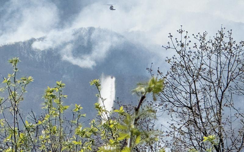 As seen from the Shute Cove overlook on the Cherohala Skyway Monday, a  helicopter drops water from Lake Santeetlah onto the Haoe Lead Fire. Photo courtesy of Jessica Wehr/U.S. Forest Service Public Information Officer