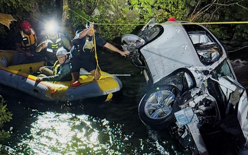 Members of the Graham County Fire and Rescue Squad work their way back to shore after rescuing James Vollmer following an accident that sent the area dentist into the Cheoah River on May 13. Photos courtesy of Graham County Fire and Rescue
