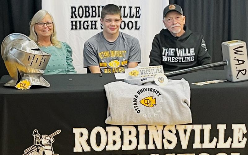 Black Knights senior Skyler Anderson signed a Letter of Intent to wrestle at Ottawa (Kan.) University on May 5. Seated with Anderson are Vickie and Dean Carpenter. Photo courtesy of Robbinsville Wrestling